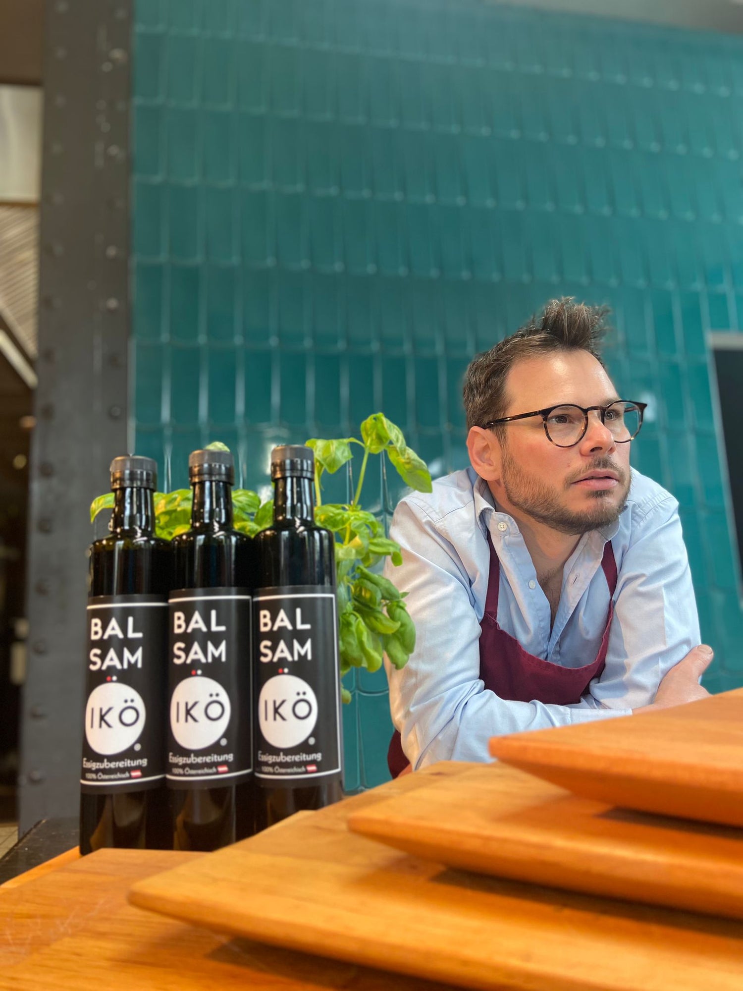 3 Flaschen BALSAMIKÖ mit Benjamin Brameshuber in einer Küche